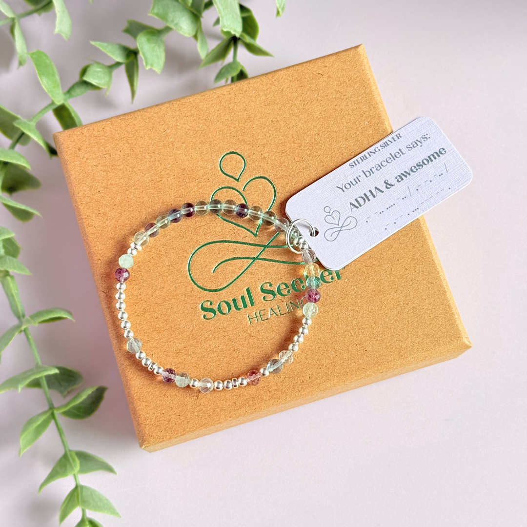 Elasticated stretch fluorite crystal morse code bracelet spelling out the words ‘ADHD and awesome’ in a combination of 4mm round fluorite beads, 4mm faceted fluorite beads and either sterling silver or gold vermeil 3mm round beads. The words start and end at the rondelle spacer beads.