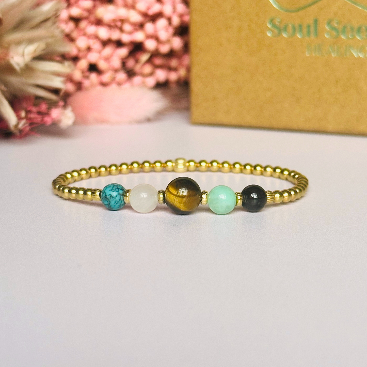 This gold vermeil Leo bracelet is made with a selection of five healing crystals all believed to resonate with the Leo zodiac sign. The central bead is 8mm, the other four are 6mm. On an elasticated band of 3mm gold vermeil beads with corrugated accent beads. Featuring chrysocolla, garnet, tigers eye, rose quartz and turquoise.
