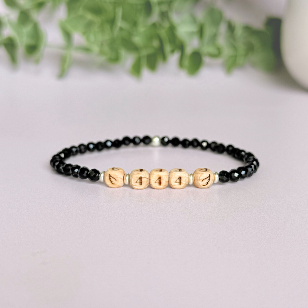 Bracelet featuring engraved wooden 444 angel number and wing beads, on the band of 4mm faceted black tourmaline round crystal gemstone beads. Finished with your choice of gold vermeil, sterling silver or rose gold vermeil accent beads.