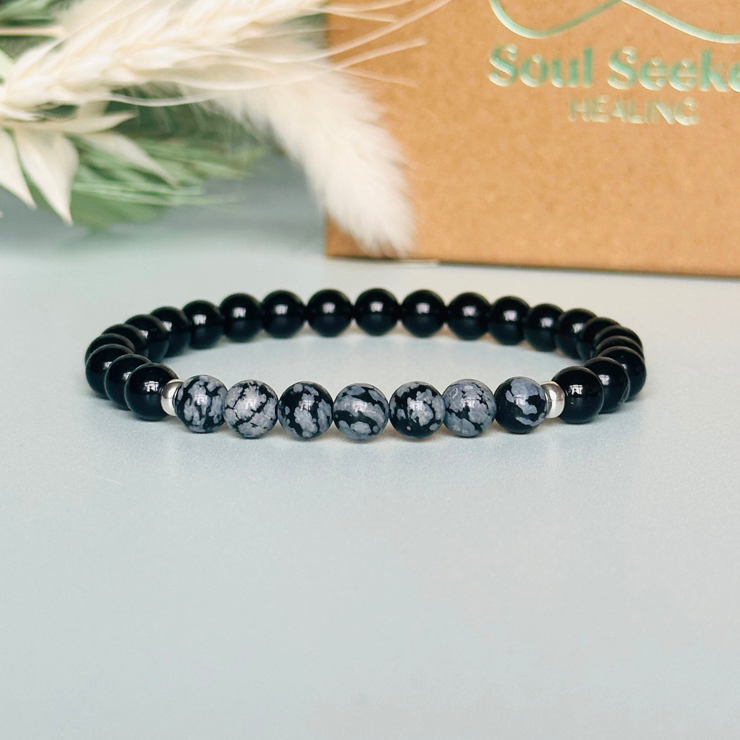 Men’s crystal bracelet featuring 6mm black tourmaline beads, 6mm snowflake obsidian beads with sterling silver spacer beads.