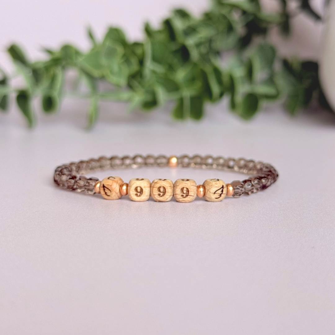 Bracelet featuring engraved wooden 999 angel number and wing beads, on the band of 4mm faceted smoky quartz round crystal gemstone beads. Finished with your choice of gold vermeil, sterling silver or rose gold vermeil accent beads.