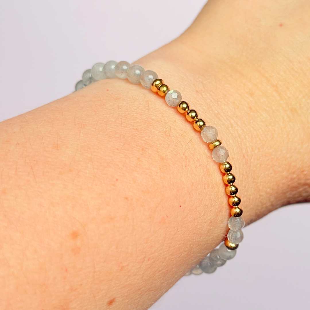 Elasticated labradorite crystal morse code bracelet that spells out the words ‘Let them’ in a combination of 4mm round labradorite beads, 4mm faceted labradorite beads and either sterling silver or gold vermeil 3mm round beads. The words start and end at the rondelle spacer beads.