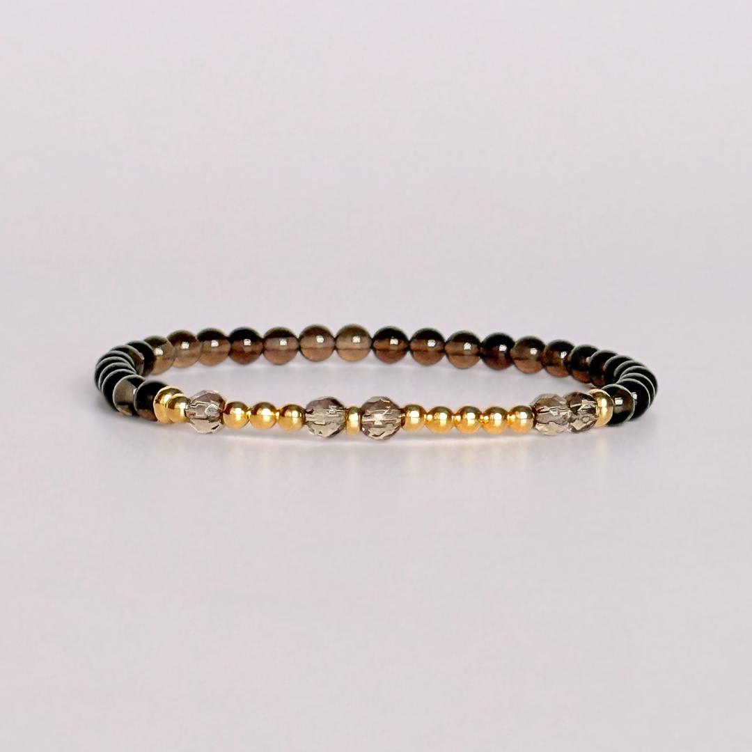 Elasticated smoky quartz crystal morse code bracelet that spells out the words ‘Let them’ in a combination of 4mm round smoky quartz beads, 4mm faceted smoky quartz beads and either sterling silver or gold vermeil 3mm round beads. The words start and end at the rondelle spacer beads.