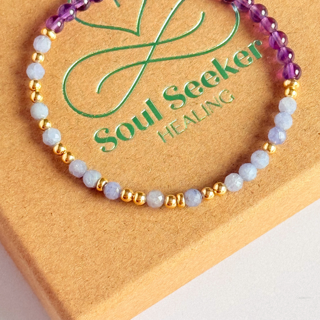 Amethyst and tanzanite elasticated stretch crystal morse code bracelet that spells out the words ‘Calm TF down’ in a combination of 4mm round amethyst beads, 4mm faceted tanzanite beads and either sterling silver or gold vermeil 3mm round beads. The words start and end at the rondelle spacer beads.