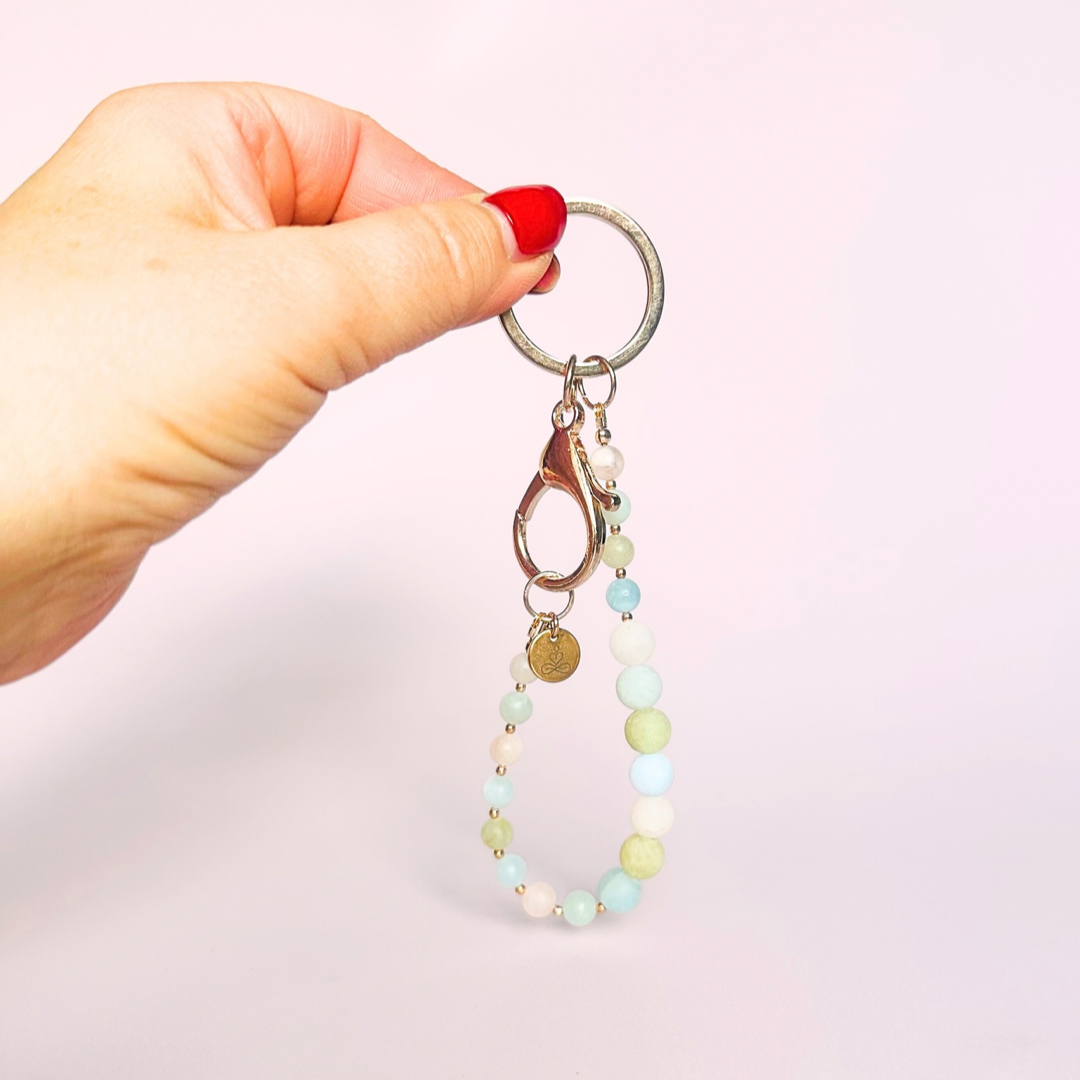 Frosted morganite breath work beads on a rose gold keychain/bag charm. For the 4-7-8 counted breathing method.