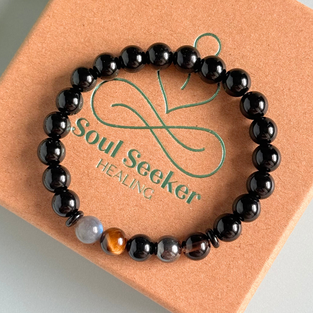 Men’s grief support bracelet featuring 8mm crystal beads which are believed to help with the various aspects of grief and loss. Includes black obsidian, black onyx, labradorite, tigers eye, hematite and smoky quartz.