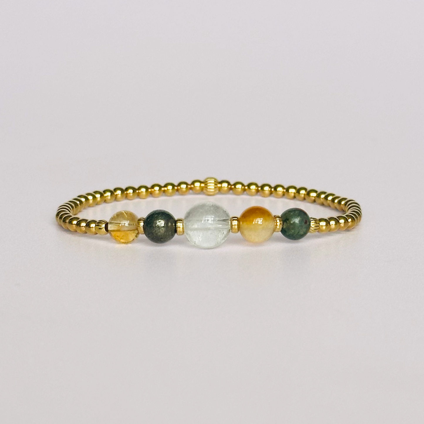 This gold vermeil Aries bracelet is made with a selection of five healing crystals all believed to resonate with the Aries zodiac sign. The central bead is 8mm, the other four are 6mm. On an elasticated band of 3mm gold vermeil beads with corrugated accent beads. Featuring citrine, bloodstone, carnelian, pyrite and clear quartz.