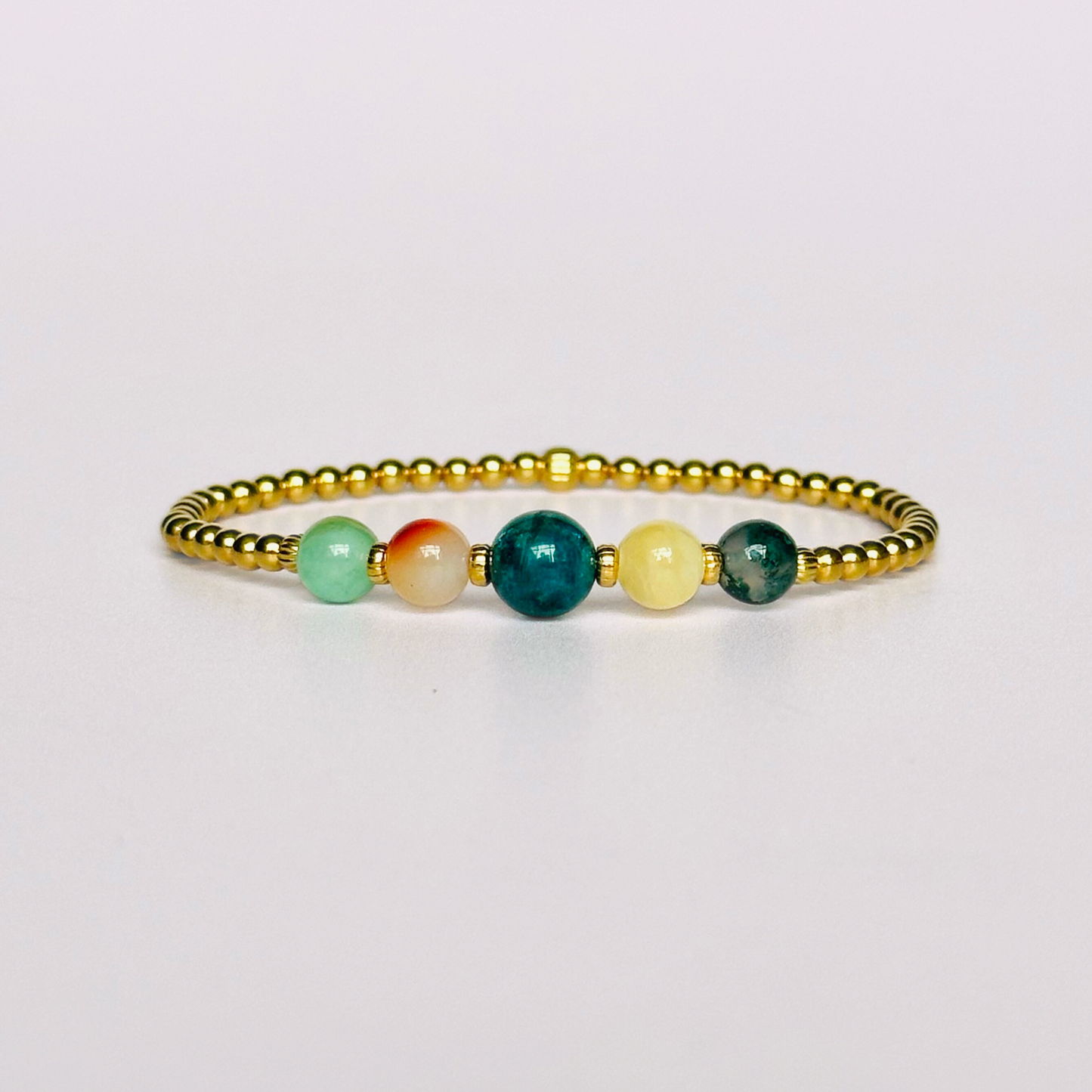 This gold vermeil Gemini bracelet is made with a selection of five healing crystals all believed to resonate with the Gemini zodiac sign. The central bead is 8mm, the other four are 6mm. On an elasticated band of 3mm gold vermeil beads with corrugated accent beads. Featuring chrysocolla, dendritic agate, apatite, yellow calcite and moss agate.