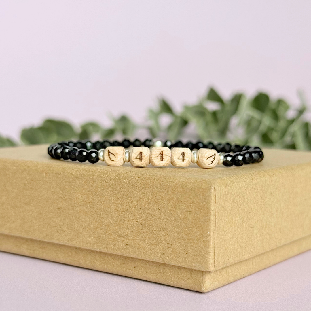 Bracelet featuring engraved wooden 444 angel number and wing beads, on the band of 4mm faceted black tourmaline round crystal gemstone beads. Finished with your choice of gold vermeil, sterling silver or rose gold vermeil accent beads.