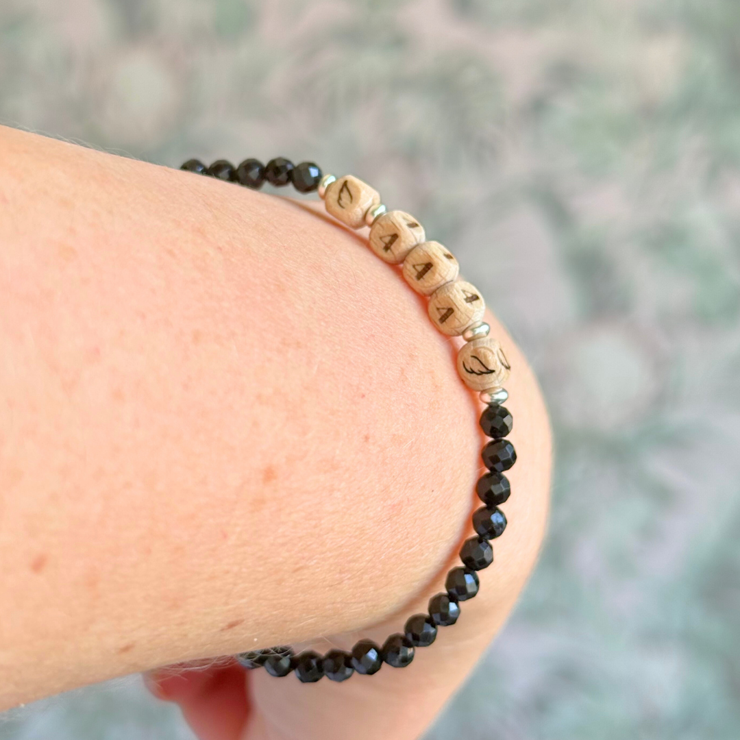 Bracelet featuring engraved wooden 444 angel number and wing beads, on the band of 4mm faceted black tourmaline round crystal gemstone beads. Finished with your choice of gold vermeil, sterling silver or rose gold vermeil accent beads.