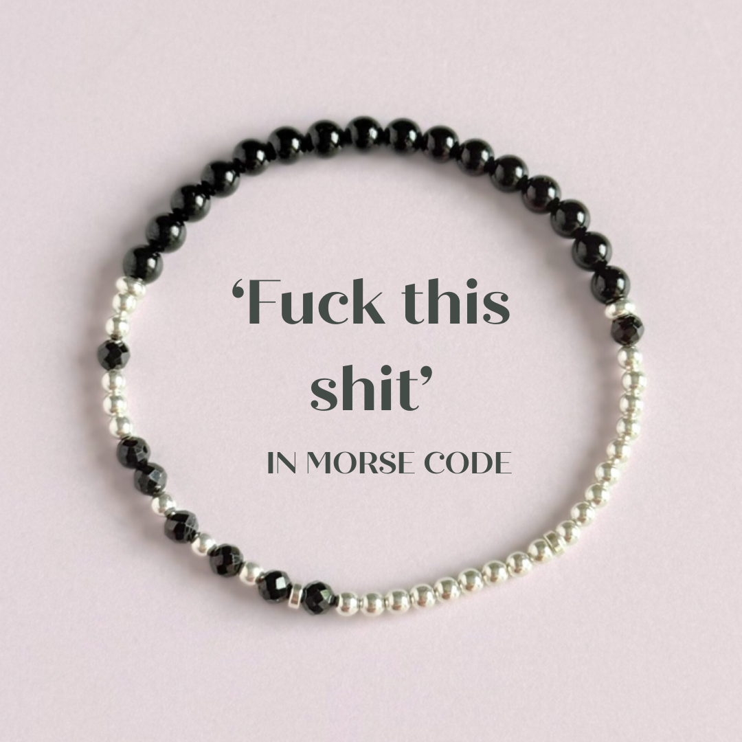Elasticated black tourmaline crystal morse code bracelet spells out the words ‘Fuck this shit’ in a combination of 4mm round black tourmaline beads, 4mm faceted black tourmaline beads and either sterling silver or gold vermeil 3mm round beads. The words start and end at the rondelle spacer beads.