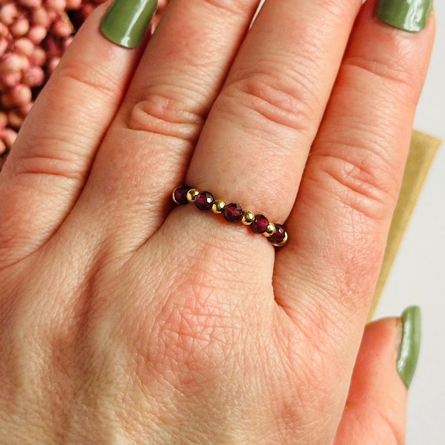Gold vermeil garnet ring featuring five 3mm faceted round garnet beads on a elasticated ring band of 2.5mm gold vermeil beads. January birthstone ring.