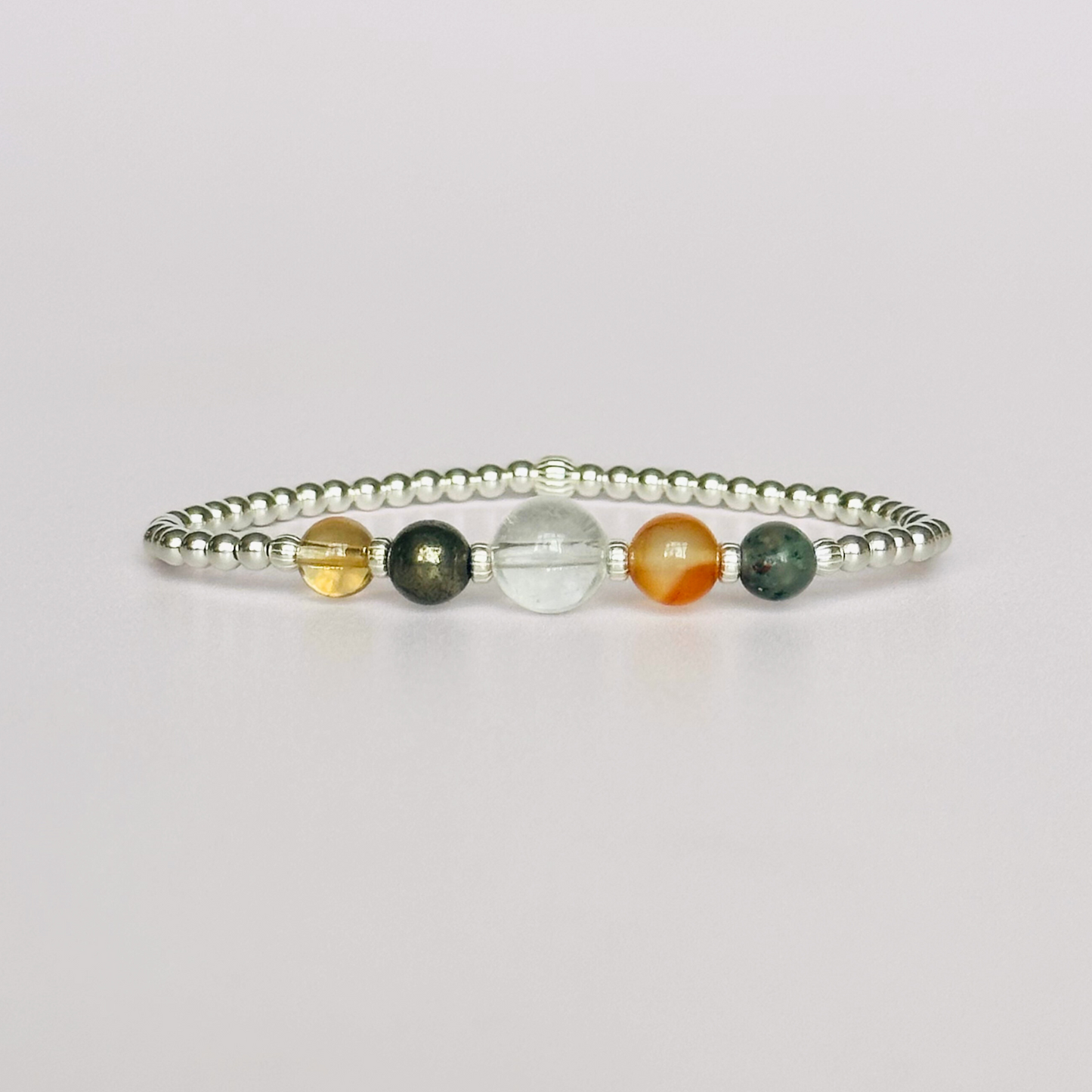 This sterling silver Aries bracelet is made with a selection of five healing crystals all believed to resonate with the Aries zodiac sign. The central bead is 8mm, the other four are 6mm. On an elasticated band of 3mm sterling silver beads with corrugated accent beads. Featuring carnelian, bloodstone, pyrite, clear quartz and citrine.