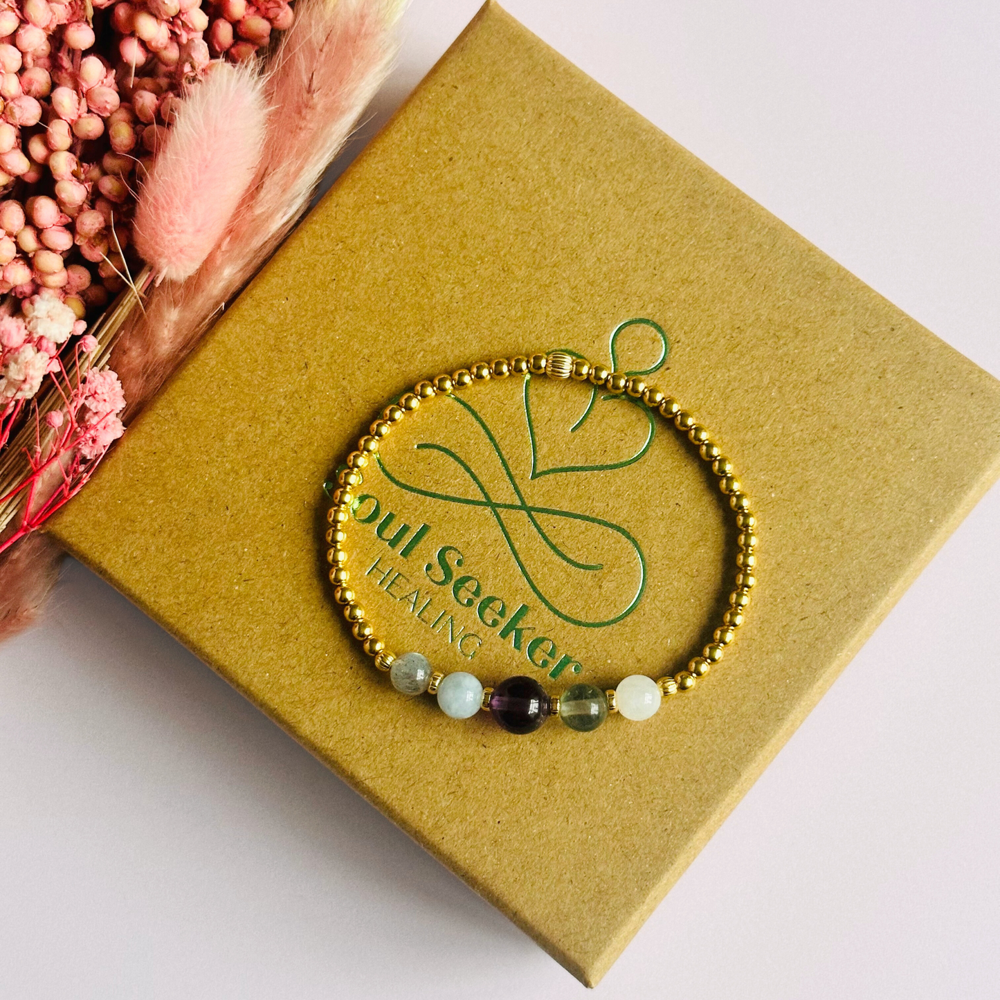 This gold vermeil Aquarius bracelet is made with a selection of five healing crystals all believed to resonate with the Aquarius zodiac sign. The central bead is 8mm, the other four are 6mm. On an elasticated band of 3mm gold vermeil beads with corrugated accent beads. Featuring labradorite, moonstone, fluorite, amethyst and aquamarine.