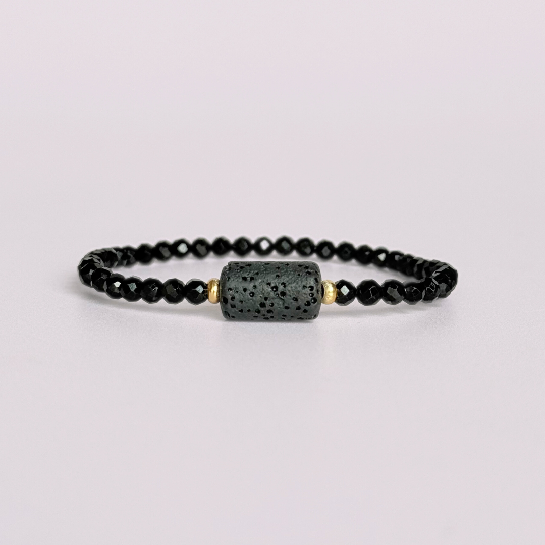 Essential oil diffuser bracelet featuring black lava rock tube bead on the band of 4mm faceted black tourmaline beads. Finished with your choice of sterling silver or gold vermeil accent beads.