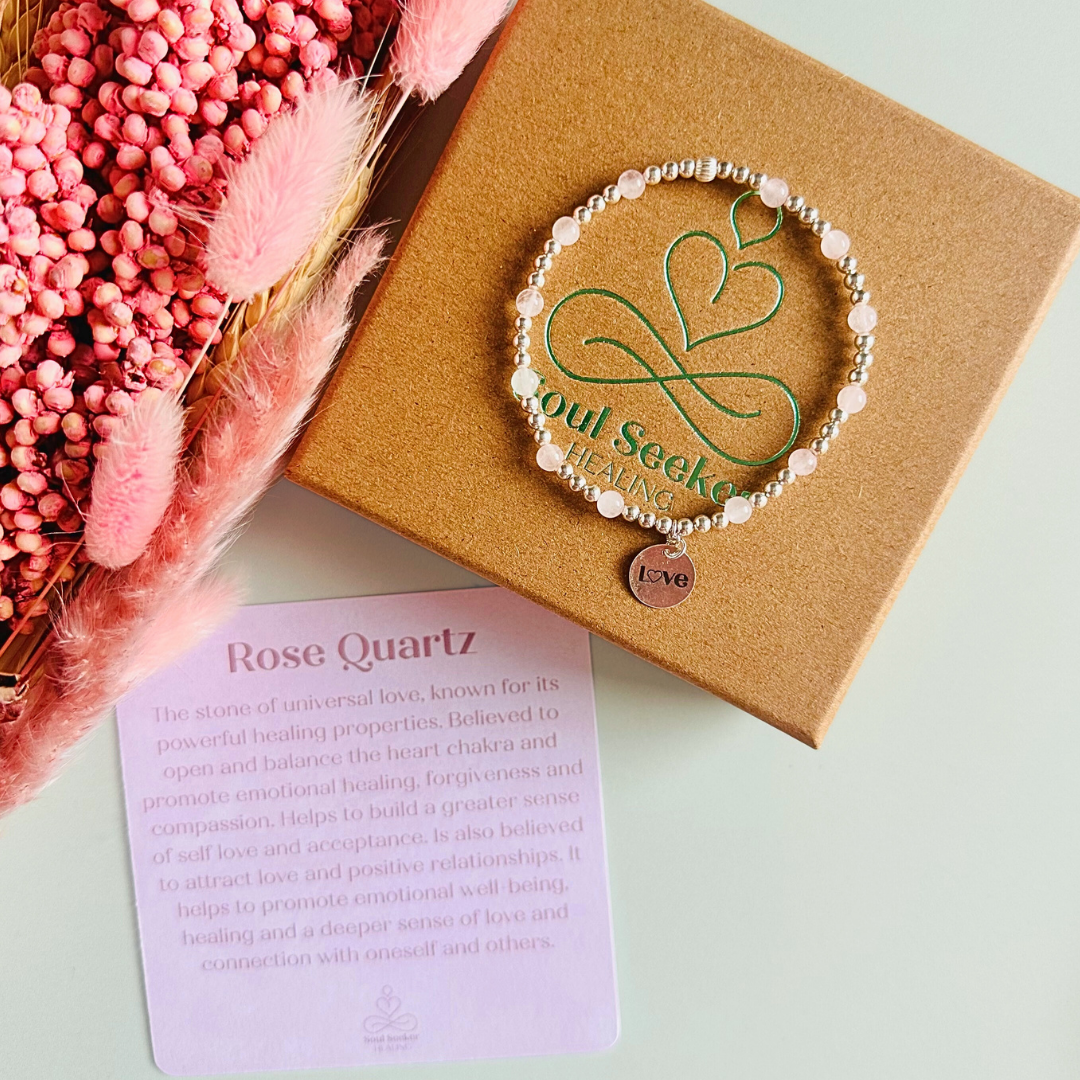 Sterling silver elasticated bracelet featuring 4mm round rose quartz beads, separated by 3mm sterling silver round ball beads. Featuring an 11mm sterling silver round disc charm engraved with the words love. One side of the charm can be personalised if required.