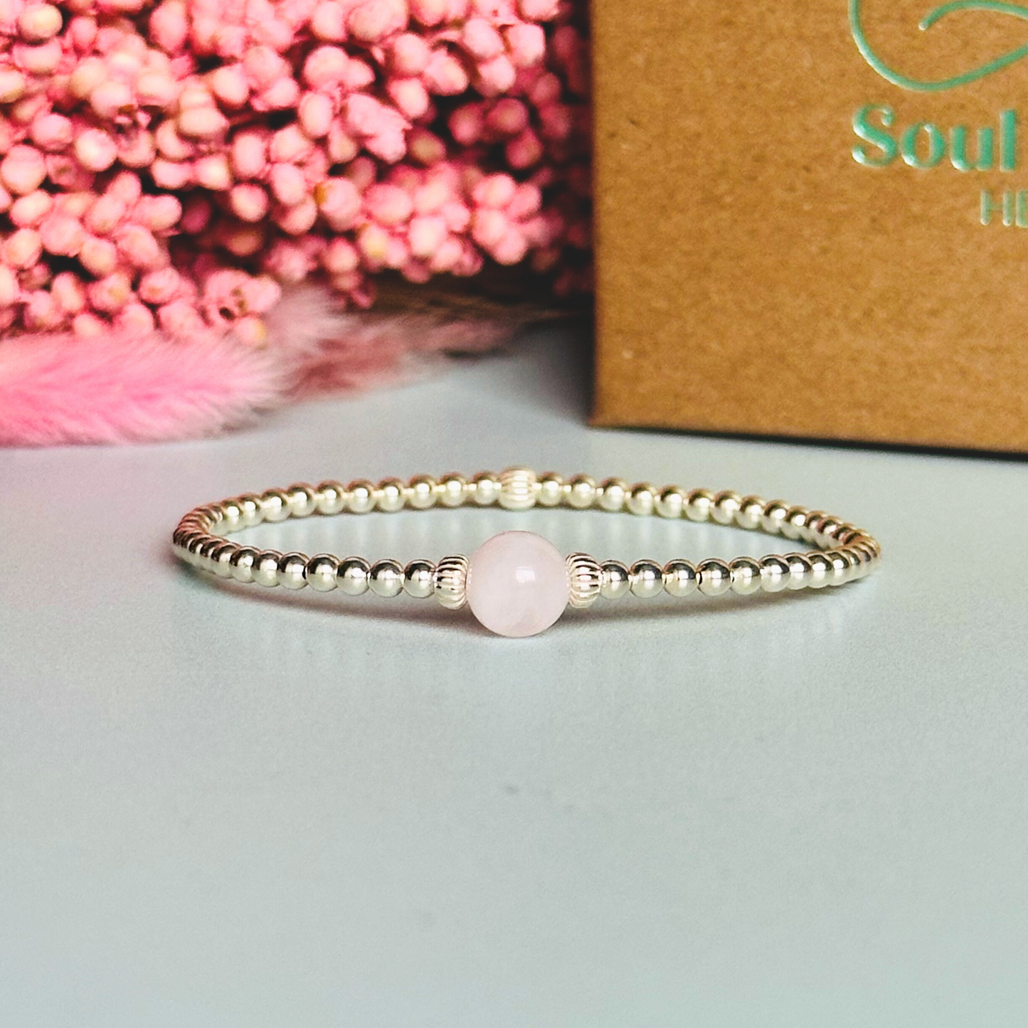 sterling silver rose quartz bracelet features an ethically mined 8mm rose quartz bead, flanked by corrugated rondelle beads on a band of 3mm sterling silver beads. A bracelet to promote self love and self-confidence.