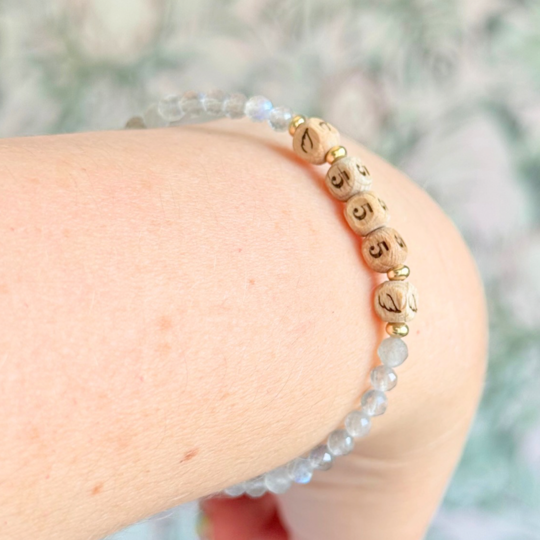 Bracelet featuring engraved wooden 555 angel number and wing beads, on the band of 4mm faceted labradorite round crystal gemstone beads. Finished with your choice of gold vermeil, sterling silver or rose gold vermeil accent beads.