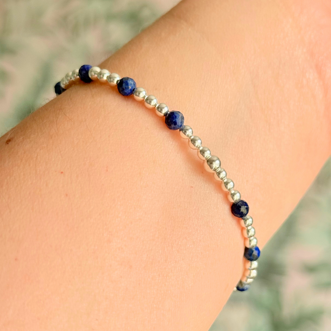 Sterling silver bracelet features 4mm lapis lazuli faceted beads, separated by 3mm sterling silver round beads. Lapis lazuli is a September birthstone. The focal point is an 11mm sterling silver charm, engraved with a large and smaller heart design. This charm can be personalised on one side if required or feature the same graphic on both sides.