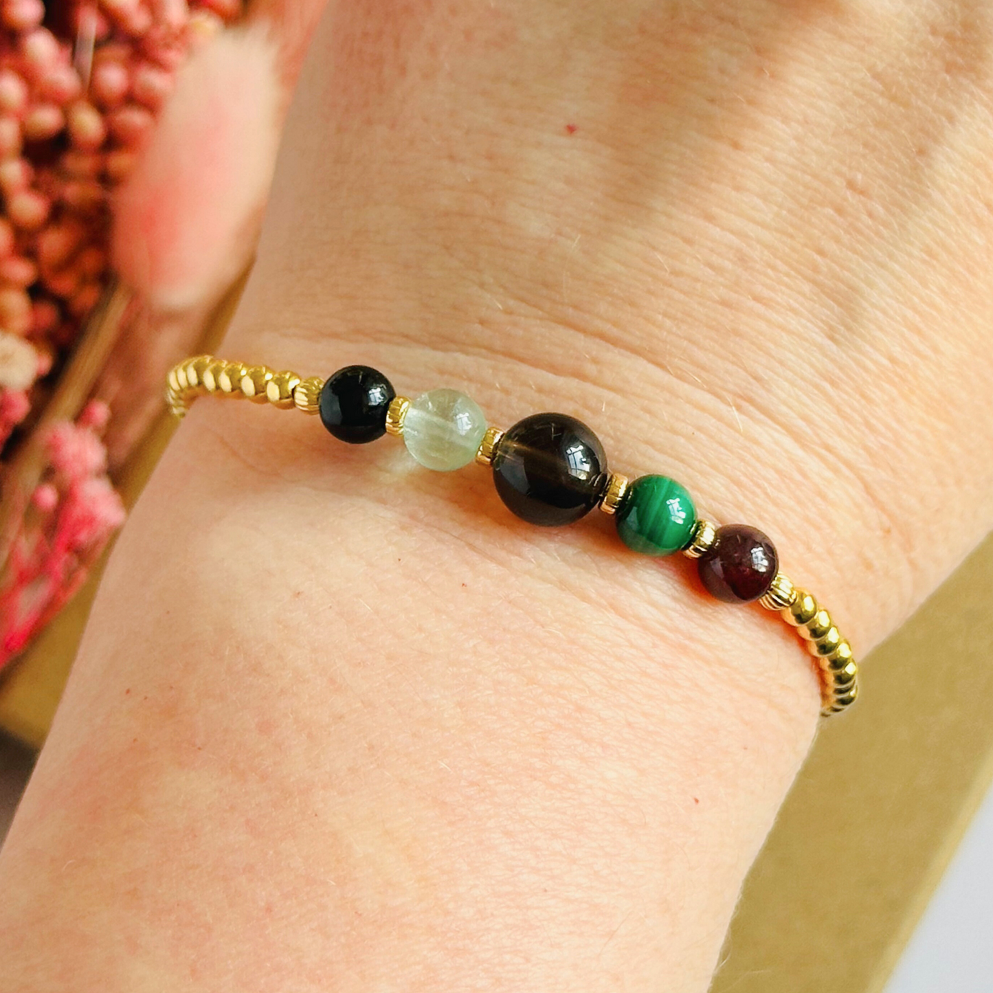 This gold vermeil Capricorn bracelet is made with a selection of five healing crystals all believed to resonate with the Capricorn zodiac sign. The central bead is 8mm, the other four are 6mm. On an elasticated band of 3mm gold vermeil beads with corrugated accent beads. Featuring garnet, malachite, fluorite, smoky quartz and black tourmaline.