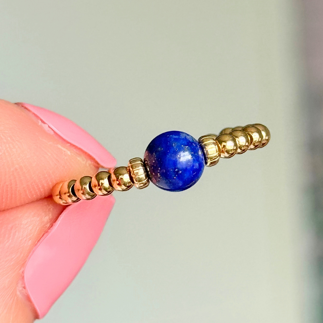 Gold vermeil beaded ring featuring a 6mm lapis lazuli round bead, flanked by gold vermeil corrugated beads. Elasticated for comfort.