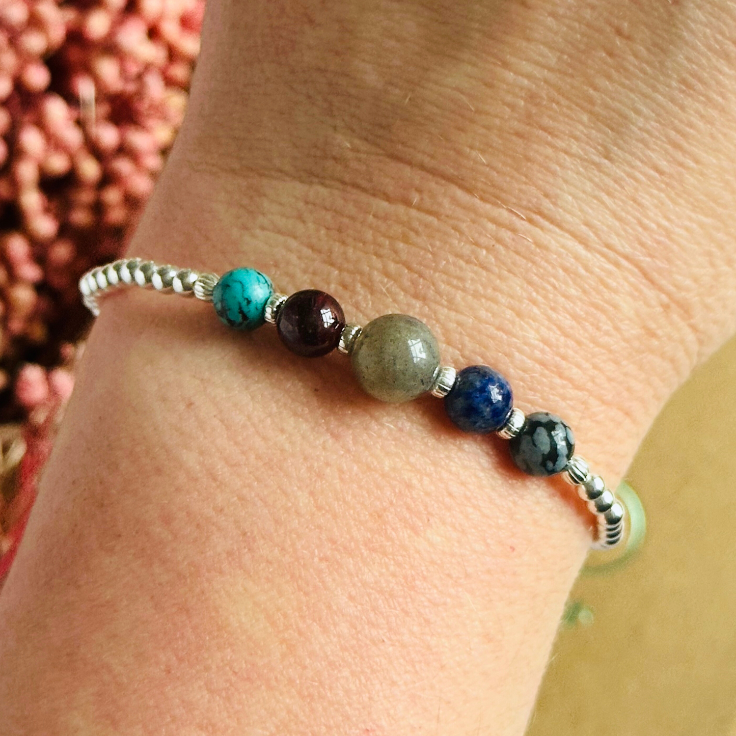 This sterling silver Sagittarius bracelet is made with a selection of five healing crystals all believed to resonate with the Sagittarius zodiac sign. The central bead is 8mm, the other four are 6mm. On an elasticated band of 3mm sterling silver beads with corrugated accent beads. Featuring garnet, labradorite, lapis lazuli, snowflake obsidian and turquoise.