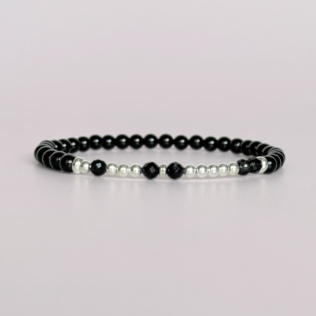 Black tourmaline crystal morse code bracelet that spells out the words ‘Let them’ in a combination of 4mm round black tourmaline beads, 4mm faceted black tourmaline beads and either sterling silver or gold vermeil 3mm round beads. The words start and end at the rondelle spacer beads.