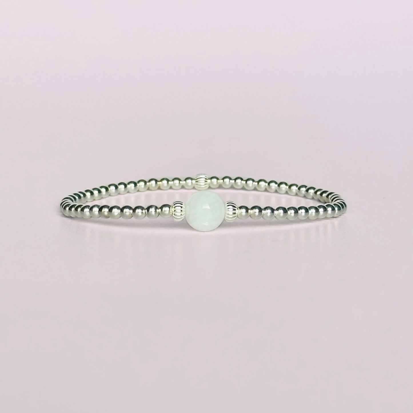 Sterling silver moonstone bracelet features an ethically mined 8mm moonstone bead, flanked by corrugated rondelle beads on a band of 3mm sterling silver beads. A bracelet to promote feminine energy and intuition.