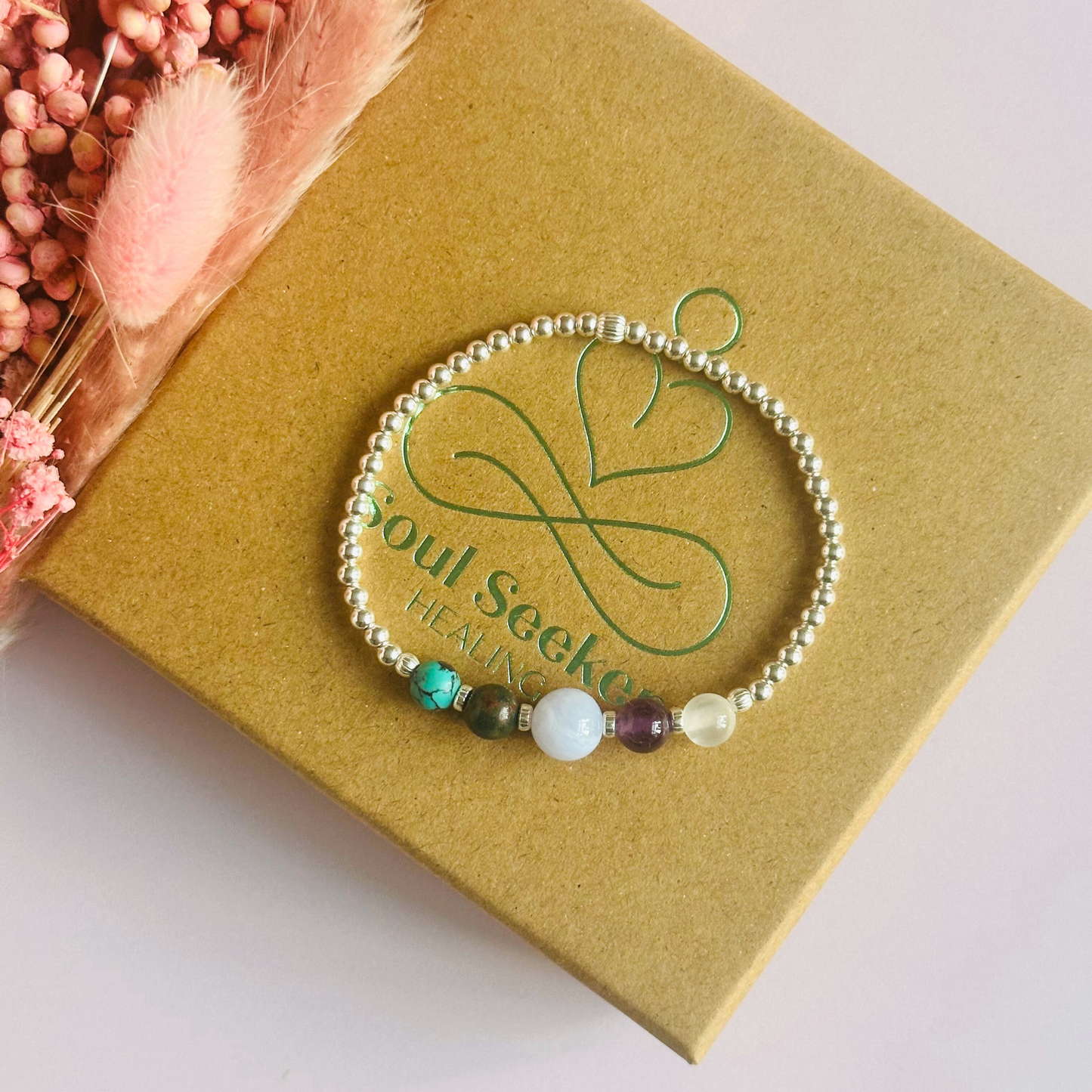 This sterling silver Pisces bracelet is made with a selection of five healing crystals all believed to resonate with the Pisces zodiac sign. The central bead is 8mm, the other four are 6mm. On an elasticated band of 3mm sterling silver beads with corrugated accent beads. Featuring turquoise, bloodstone, blue lace agate, amethyst and selenite.