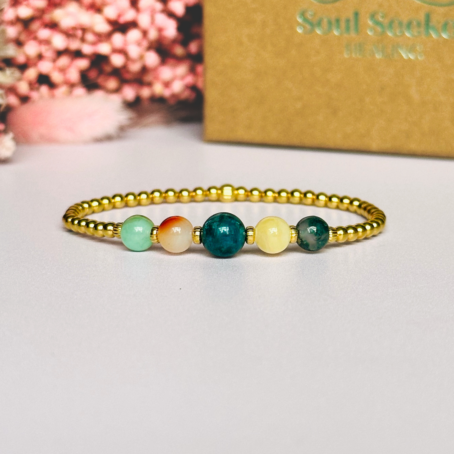This gold vermeil Gemini bracelet is made with a selection of five healing crystals all believed to resonate with the Gemini zodiac sign. The central bead is 8mm, the other four are 6mm. On an elasticated band of 3mm gold vermeil beads with corrugated accent beads. Featuring chrysocolla, dendritic agate, apatite, yellow calcite and moss agate.