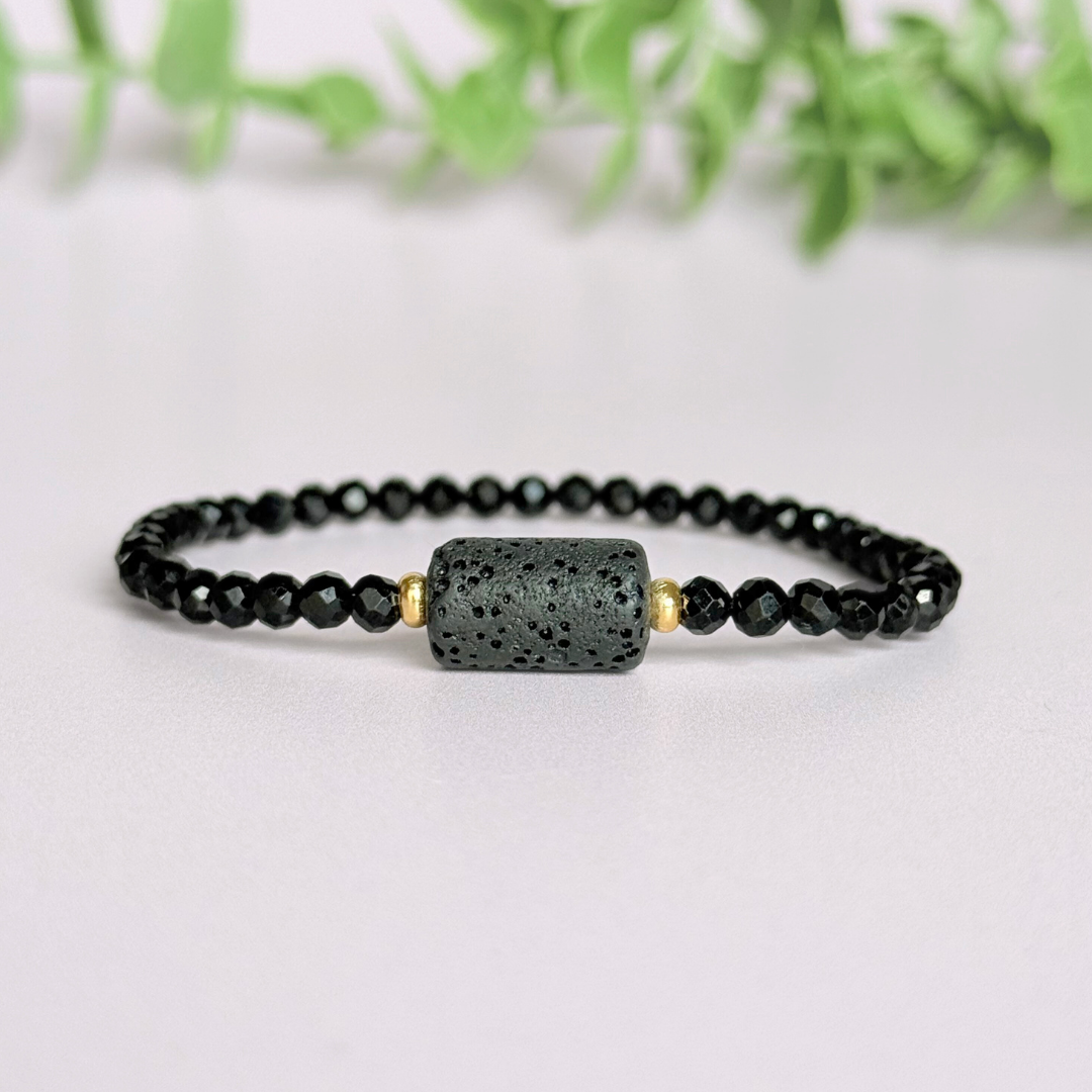 Essential oil diffuser bracelet featuring black lava rock tube bead on the band of 4mm faceted black tourmaline beads. Finished with your choice of sterling silver or gold vermeil accent beads.