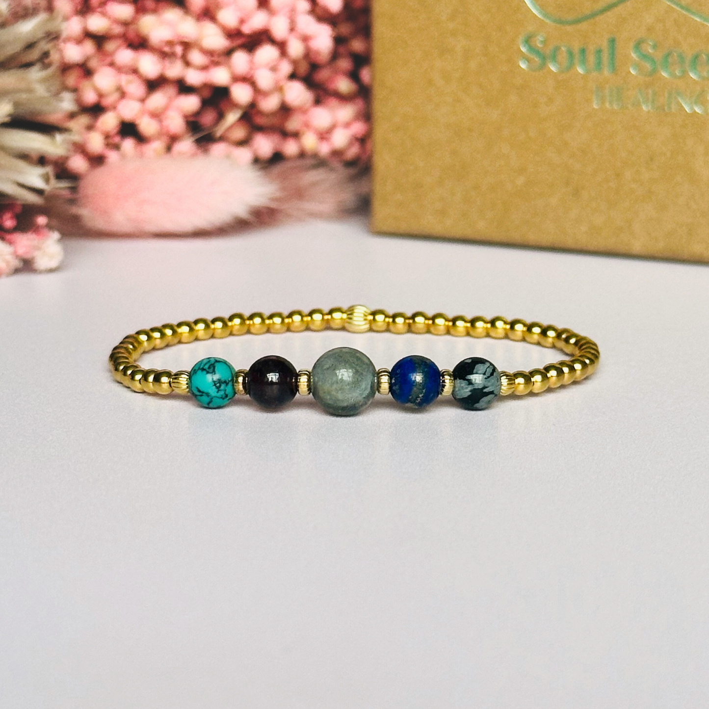 This gold vermeil Sagittarius bracelet is made with a selection of five healing crystals all believed to resonate with the Sagittarius zodiac sign. The central bead is 8mm, the other four are 6mm. On an elasticated band of 3mm gold vermeil beads with corrugated accent beads. Featuring garnet, labradorite, lapis lazuli, snowflake obsidian and turquoise.