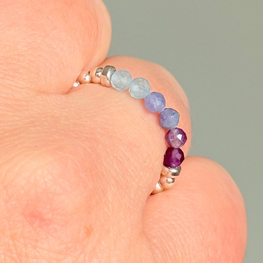 Sterling silver band style ombré ring with multicolour 3mm faceted amethyst tanzanite and aquamarine, beads with a beaded band of 2.5 mm sterling silver round beads. Elasticated for comfort.