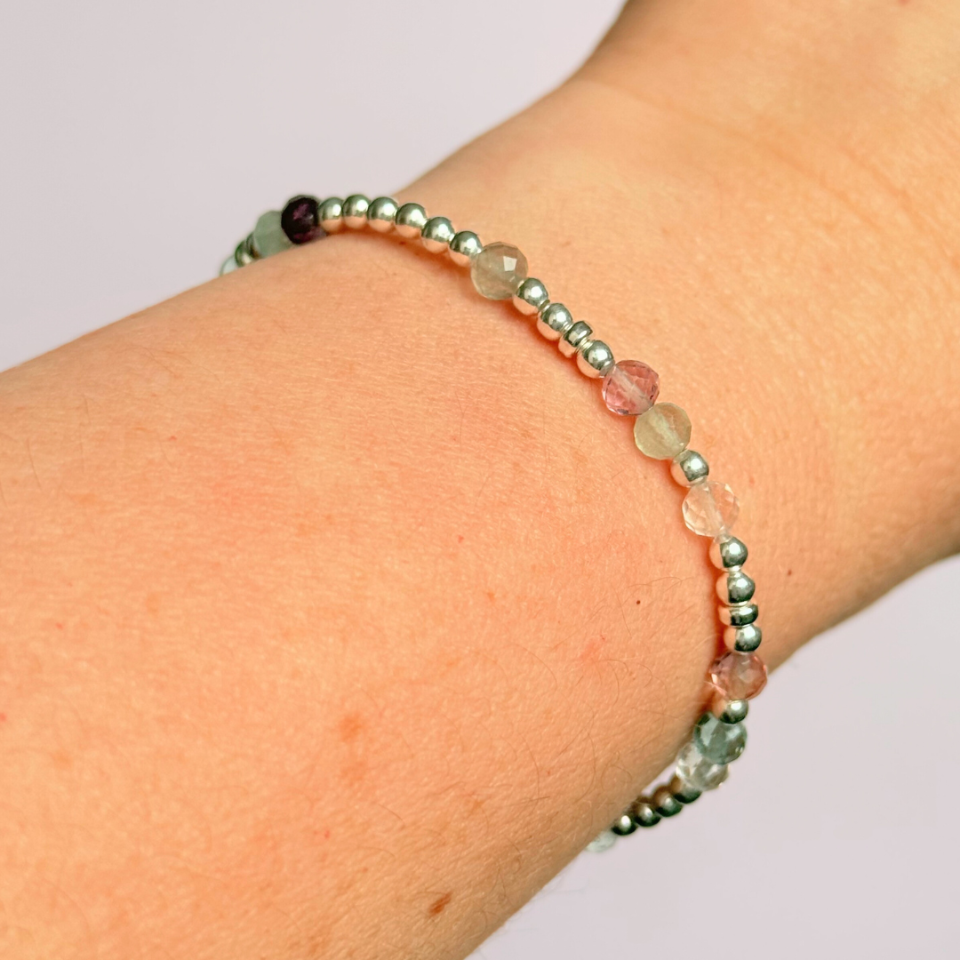 Elasticated stretch fluorite crystal morse code bracelet spelling out the words ‘ADHD and awesome’ in a combination of 4mm round fluorite beads, 4mm faceted fluorite beads and either sterling silver or gold vermeil 3mm round beads. The words start and end at the rondelle spacer beads.