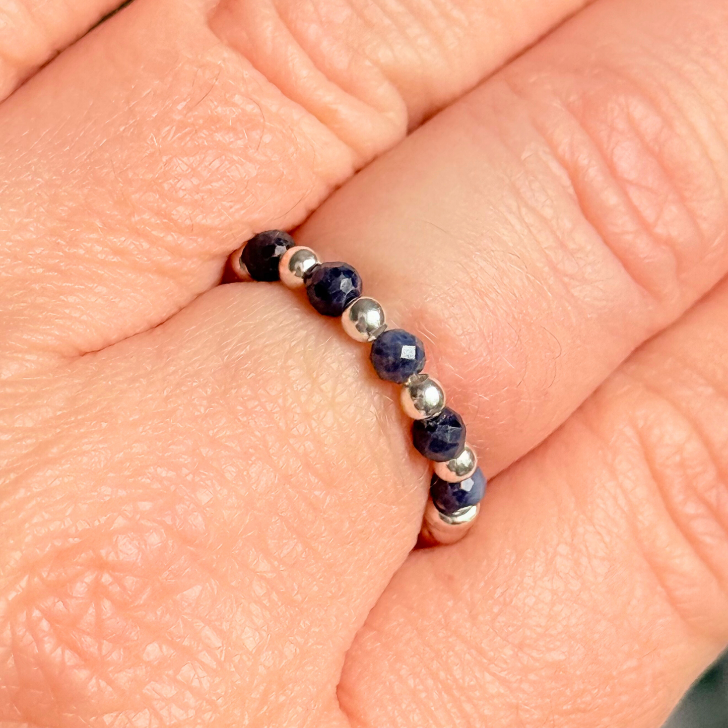 Sterling silver and sapphire crystal ring. Made with 2.5 mm sterling silver round beads and featuring five, 3mm faceted genuine sapphire beads in a band style. Perfect for stacking. September birthstone jewellery