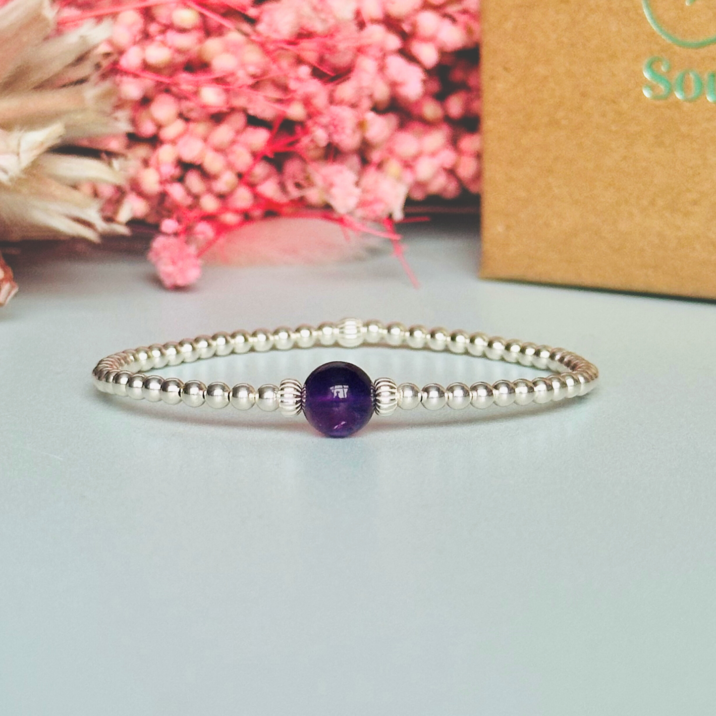 Sterling silver amethyst bracelet features an ethically mined 8mm amethyst bead, flanked by corrugated rondelle beads on a band of 3mm sterling silver beads. A bracelet to promote inner peace and calm.
