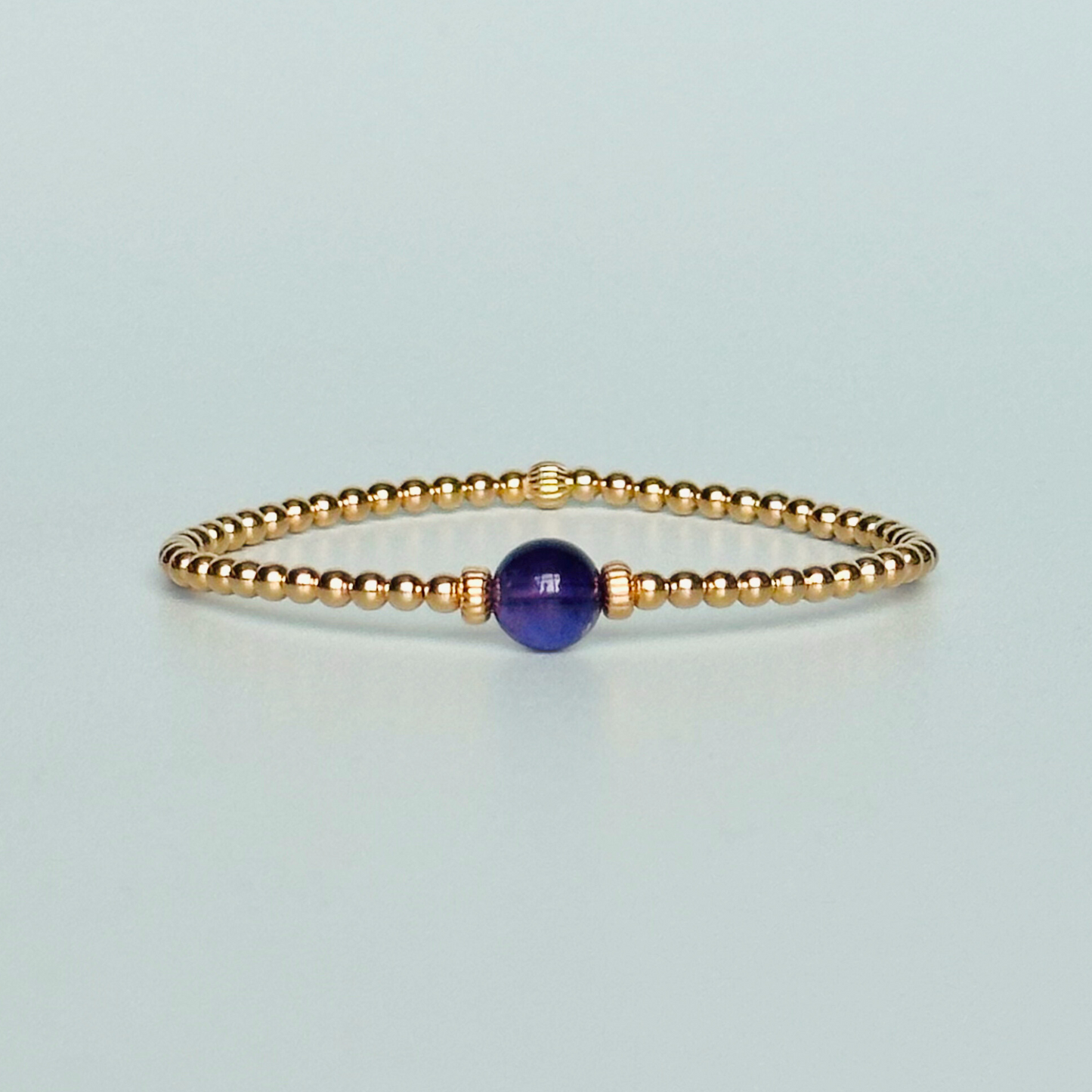 Gold vermeil amethyst bracelet features an ethically mined 8mm amethyst bead, flanked by corrugated rondelle beads on a band of 3mm gold vermeil beads. A bracelet to promote inner peace and calm.