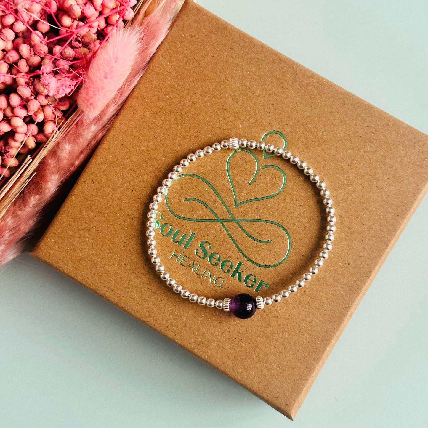 Sterling silver amethyst bracelet features an ethically mined 8mm amethyst bead, flanked by corrugated rondelle beads on a band of 3mm sterling silver beads. A bracelet to promote inner peace and calm.