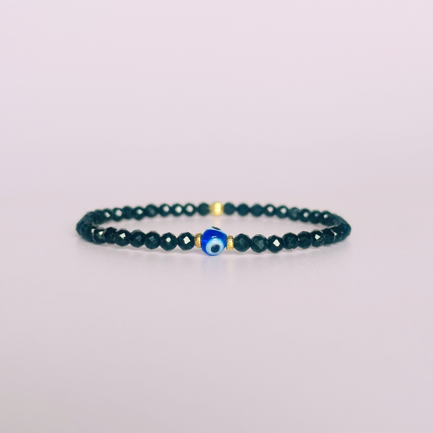 Dainty natural black tourmaline bracelet featuring ethically mined 4mm faceted gemstone beads, with a beautiful Turkish evil eye glass bead as the focal point. Choose from sterling silver or gold vermeil accent beads.