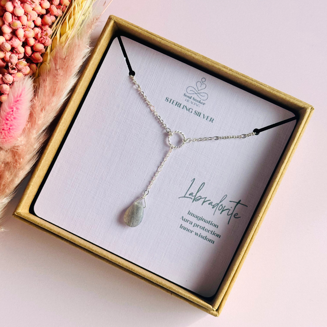 Labradorite necklace featuring a faceted labradorite teardrop bead on a delicate sterling silver chain with a twisted sterling silver ring focal point. The necklace fastens with a subtle yet secure sterling silver bolt clasp. The teardrop bead measures 12mm x 8mm.