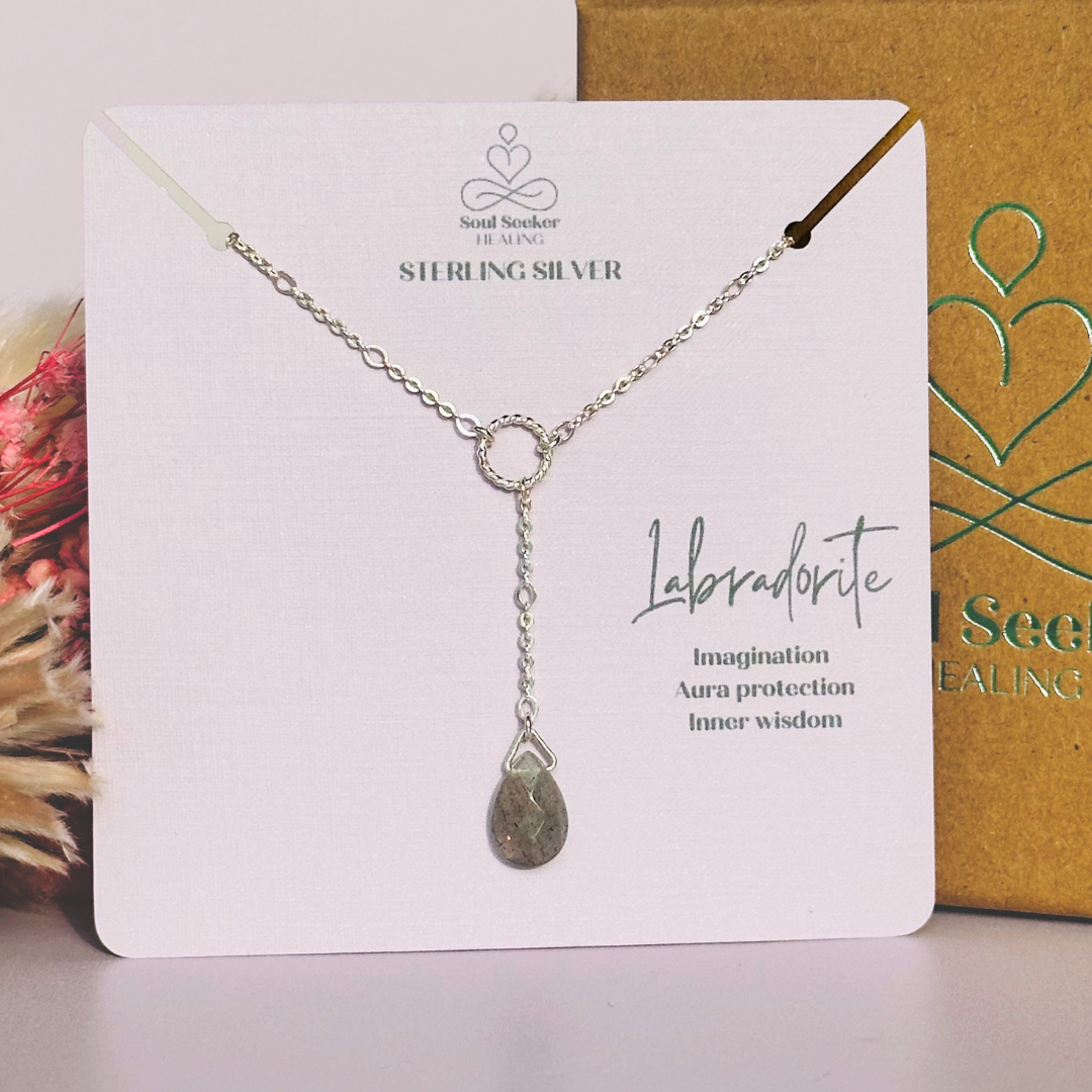 Labradorite necklace featuring a faceted labradorite teardrop bead on a delicate sterling silver chain with a twisted sterling silver ring focal point. The necklace fastens with a subtle yet secure sterling silver bolt clasp. The teardrop bead measures 12mm x 8mm.
