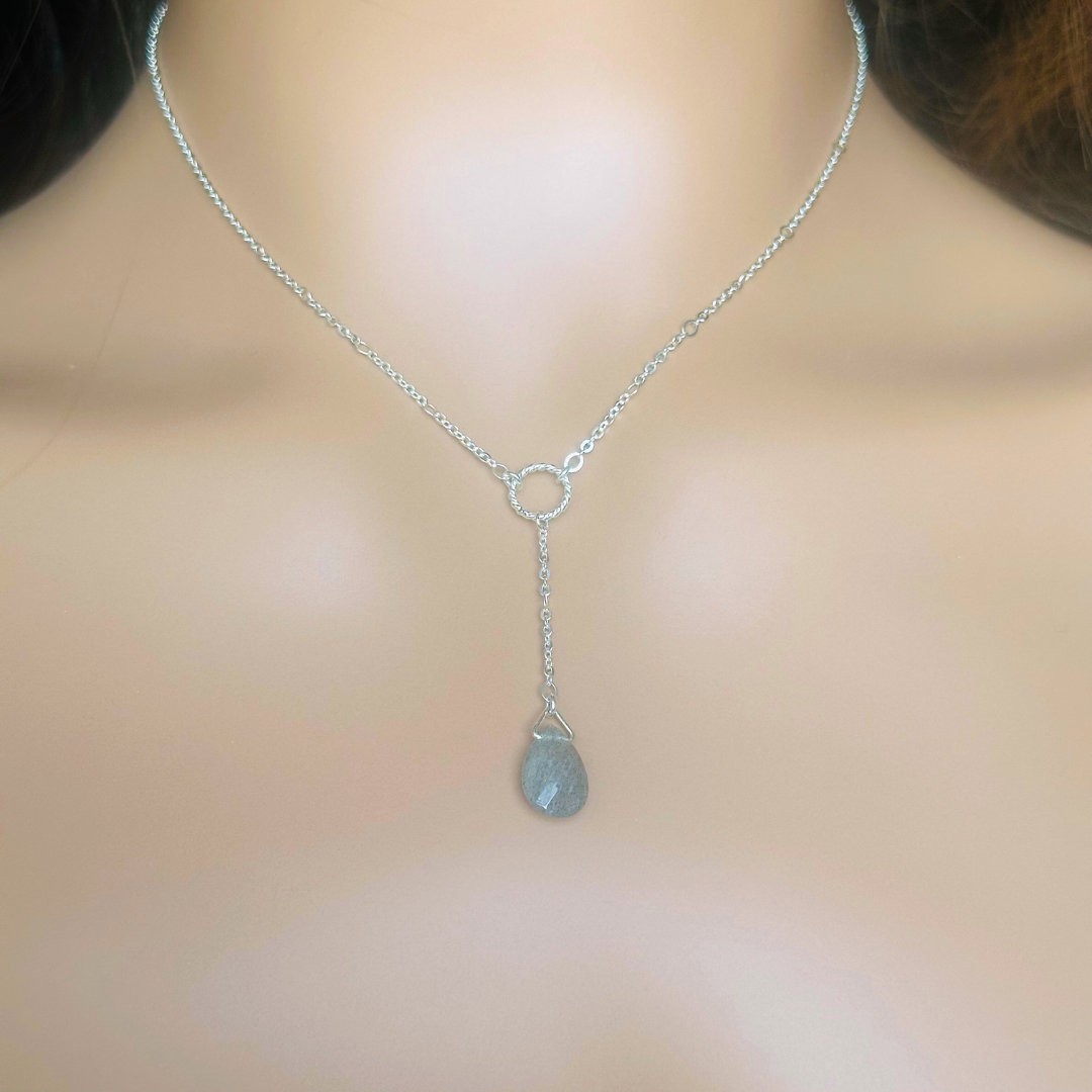Labradorite necklace featuring a faceted labradorite teardrop bead on a delicate sterling silver chain with a twisted sterling silver ring focal point. The necklace fastens with a subtle yet secure sterling silver bolt clasp. The teardrop bead measures 12mm x 8mm.
