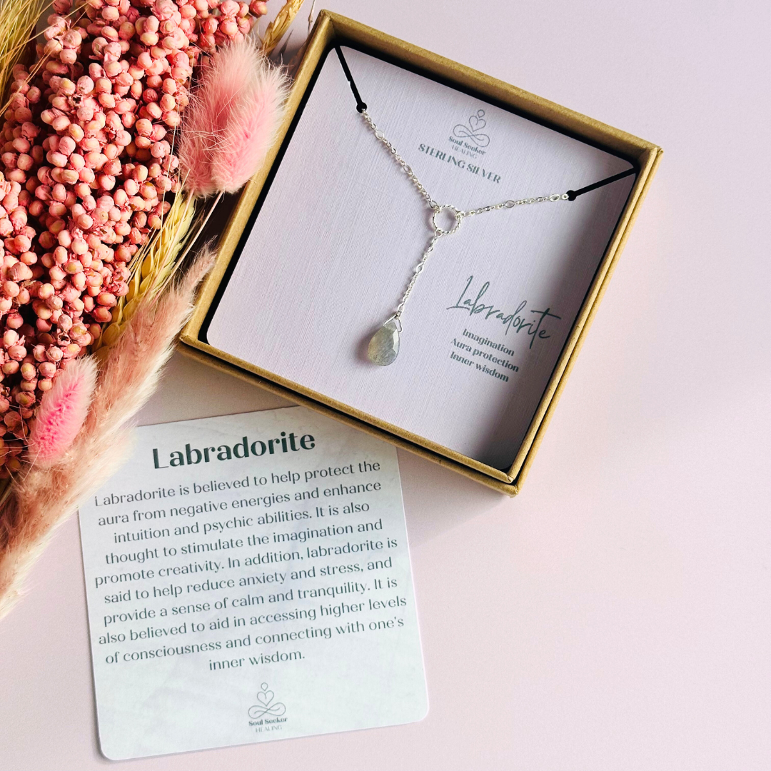 Labradorite necklace featuring a faceted labradorite teardrop bead on a delicate sterling silver chain with a twisted sterling silver ring focal point. The necklace fastens with a subtle yet secure sterling silver bolt clasp. The teardrop bead measures 12mm x 8mm.