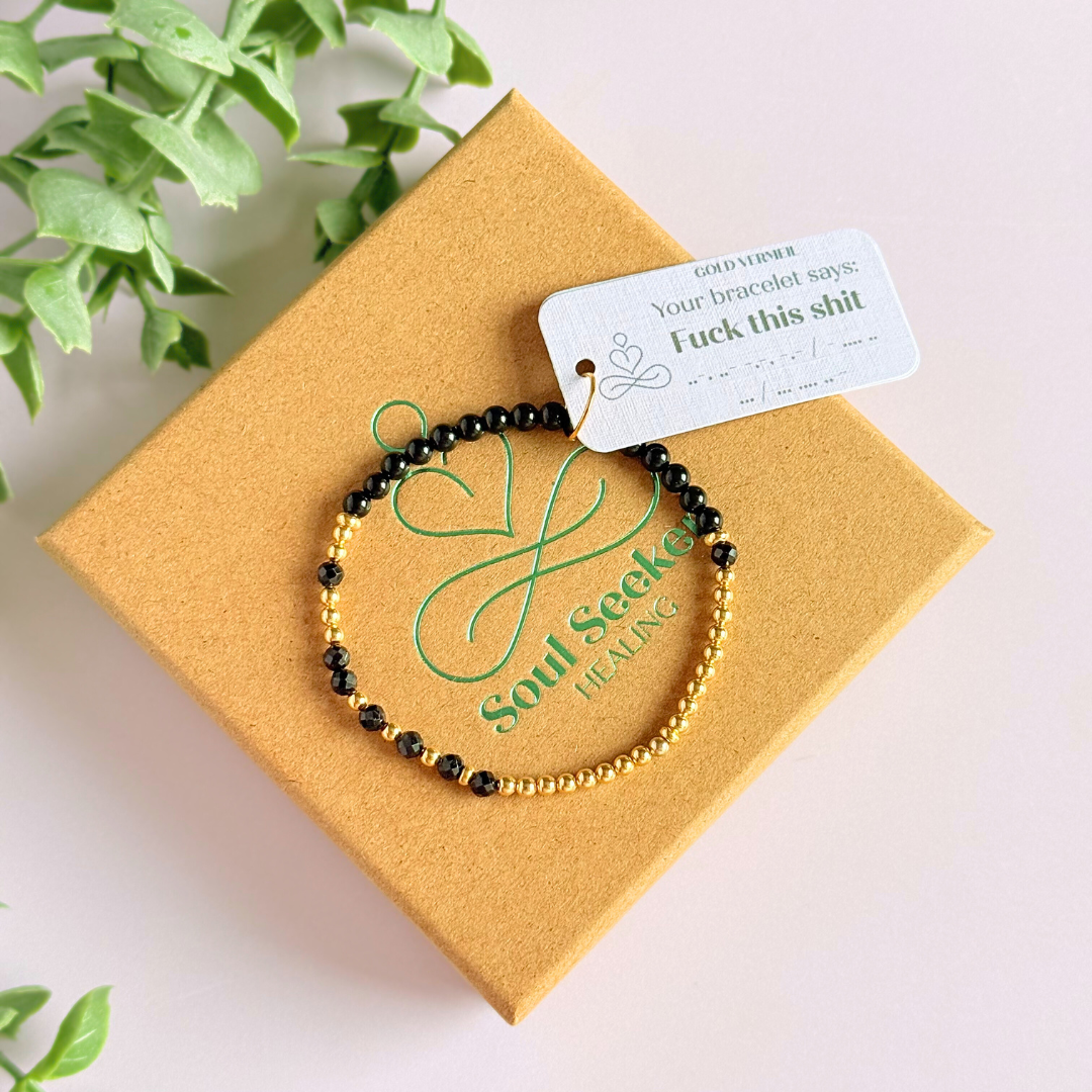 Elasticated black tourmaline crystal morse code bracelet spells out the words ‘Fuck this shit’ in a combination of 4mm round black tourmaline beads, 4mm faceted black tourmaline beads and either sterling silver or gold vermeil 3mm round beads. The words start and end at the rondelle spacer beads.
