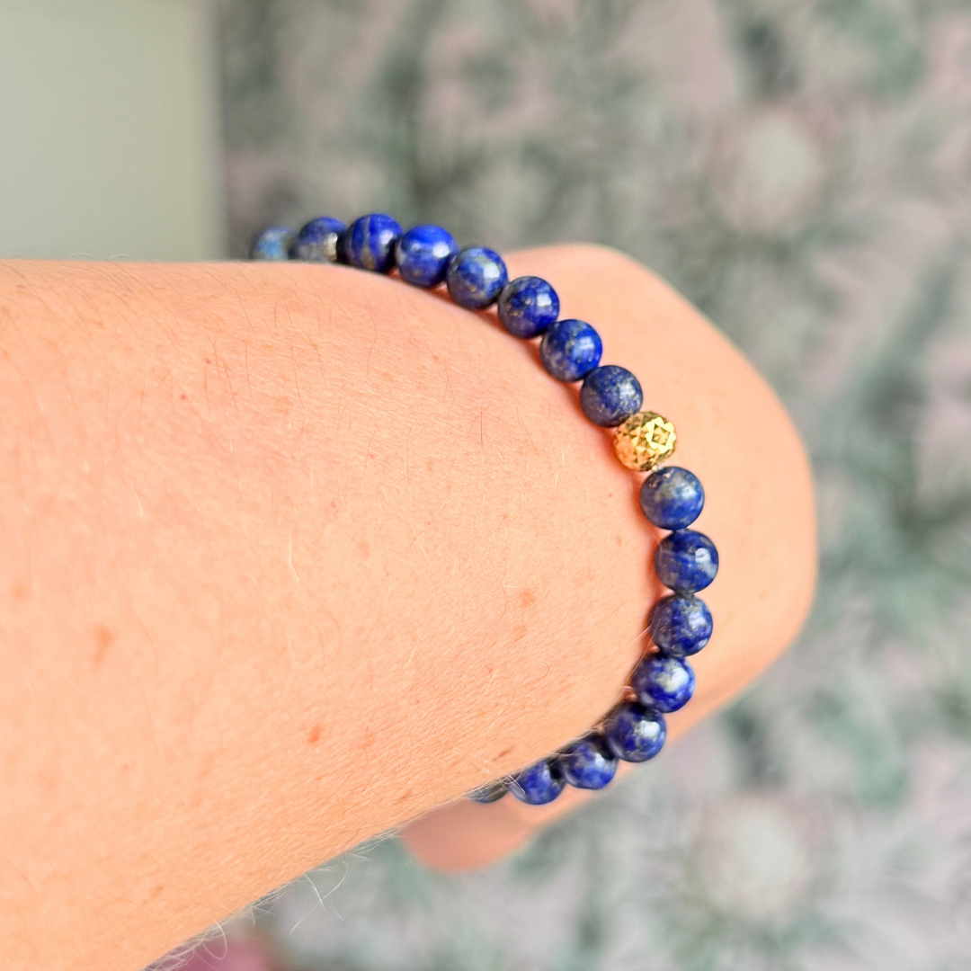 Genuine lapis lazuli bracelet featuring 6mm, smooth, round dark blue lapis lazuli beads and your choice of a 6mm faceted gold vermeil or sterling silver accent bead. Elasticated for comfort.