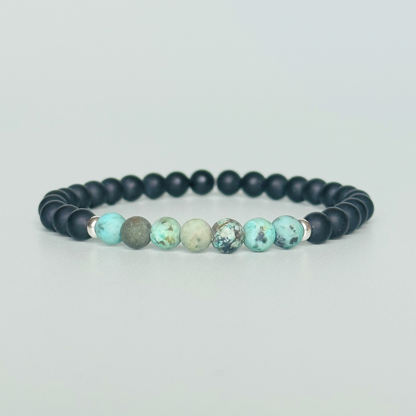 Men’s crystal bracelet featuring 6mm matte black onyx beads, 6mm matte African turquoise beads with sterling silver spacer beads.