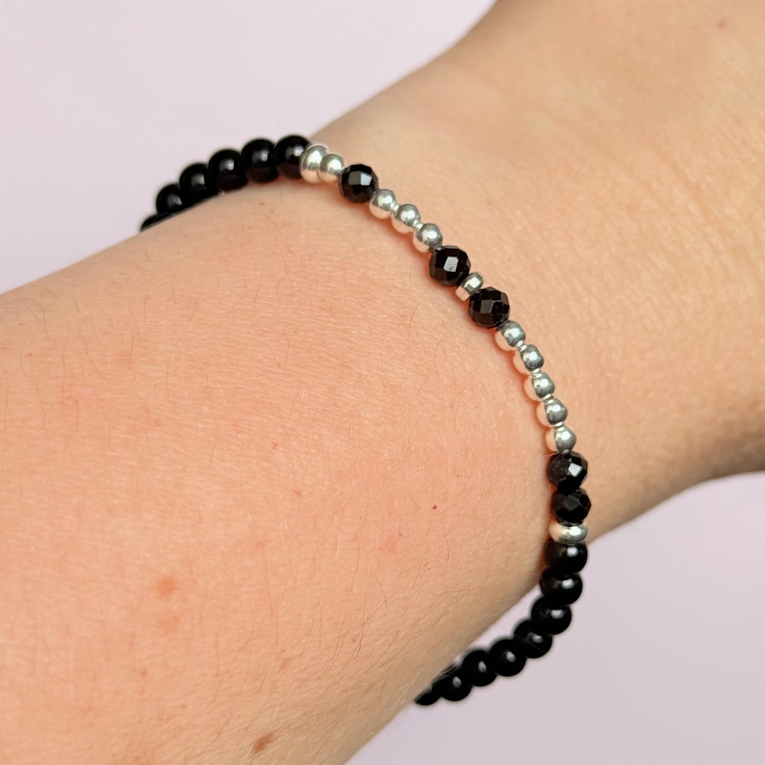 Black tourmaline crystal morse code bracelet that spells out the words ‘Let them’ in a combination of 4mm round black tourmaline beads, 4mm faceted black tourmaline beads and either sterling silver or gold vermeil 3mm round beads. The words start and end at the rondelle spacer beads.