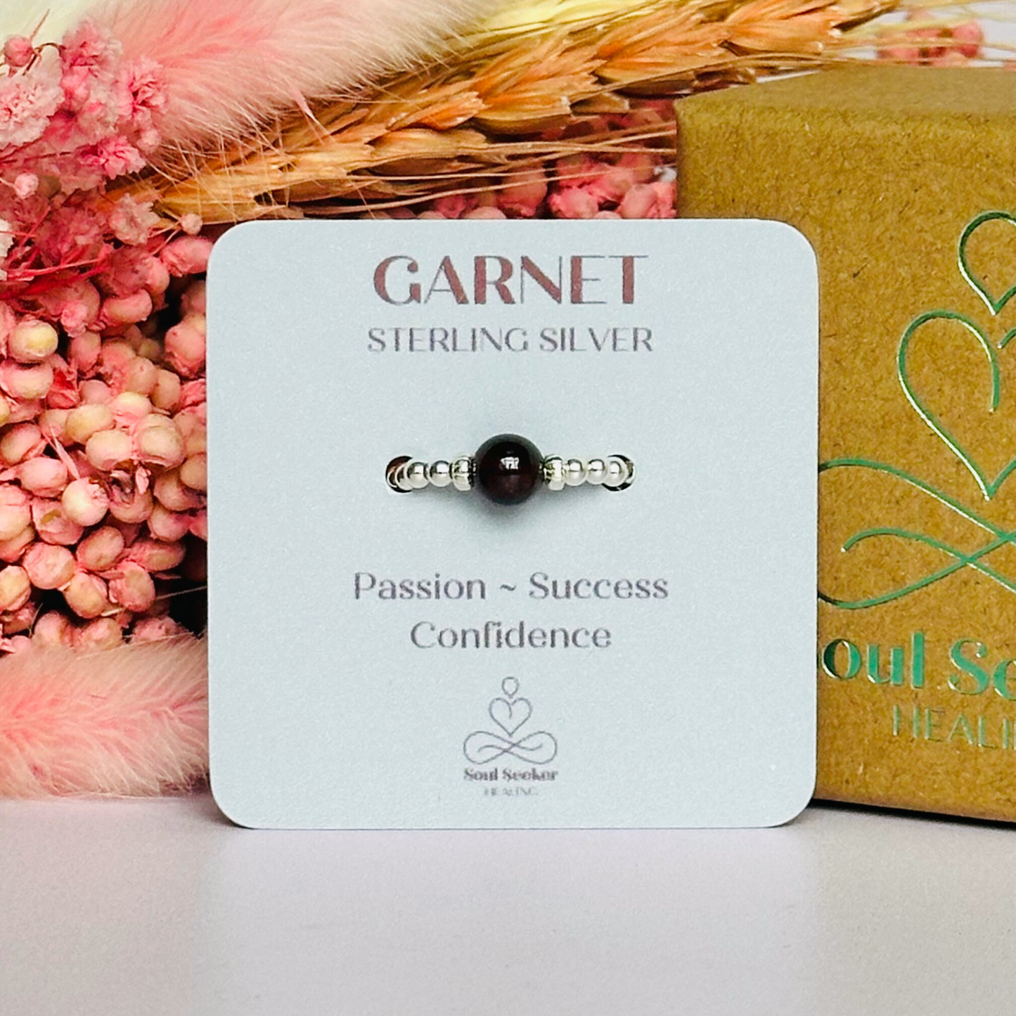 Sterling silver garnet ring featuring a 6mm smooth round garnet bead on a elasticated ring band of 2.5mm sterling silver beads.
