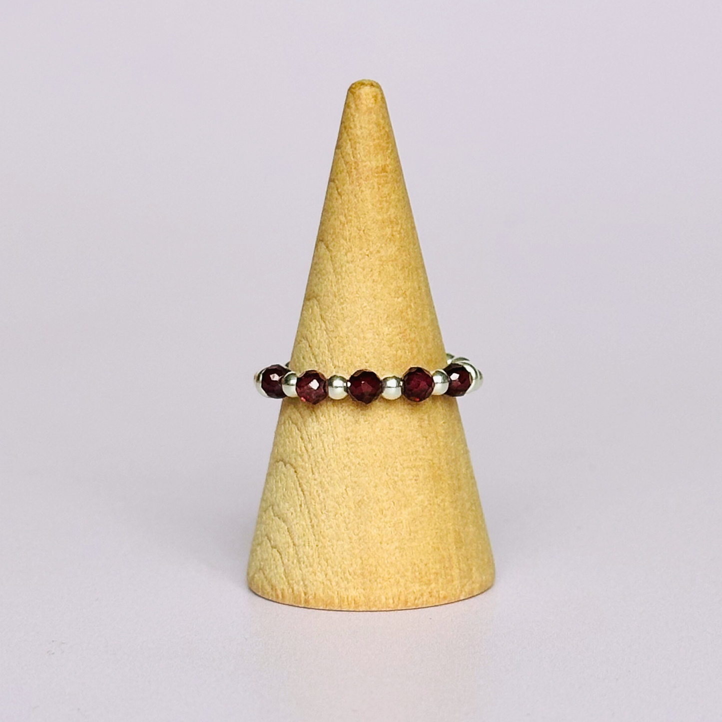 Sterling silver garnet band ring featuring five 3mm faceted round ethically sourced garnet beads, surrounded by sterling silver rondelle beads and delicate 2.5mm sterling silver beads. January birthstone ring.