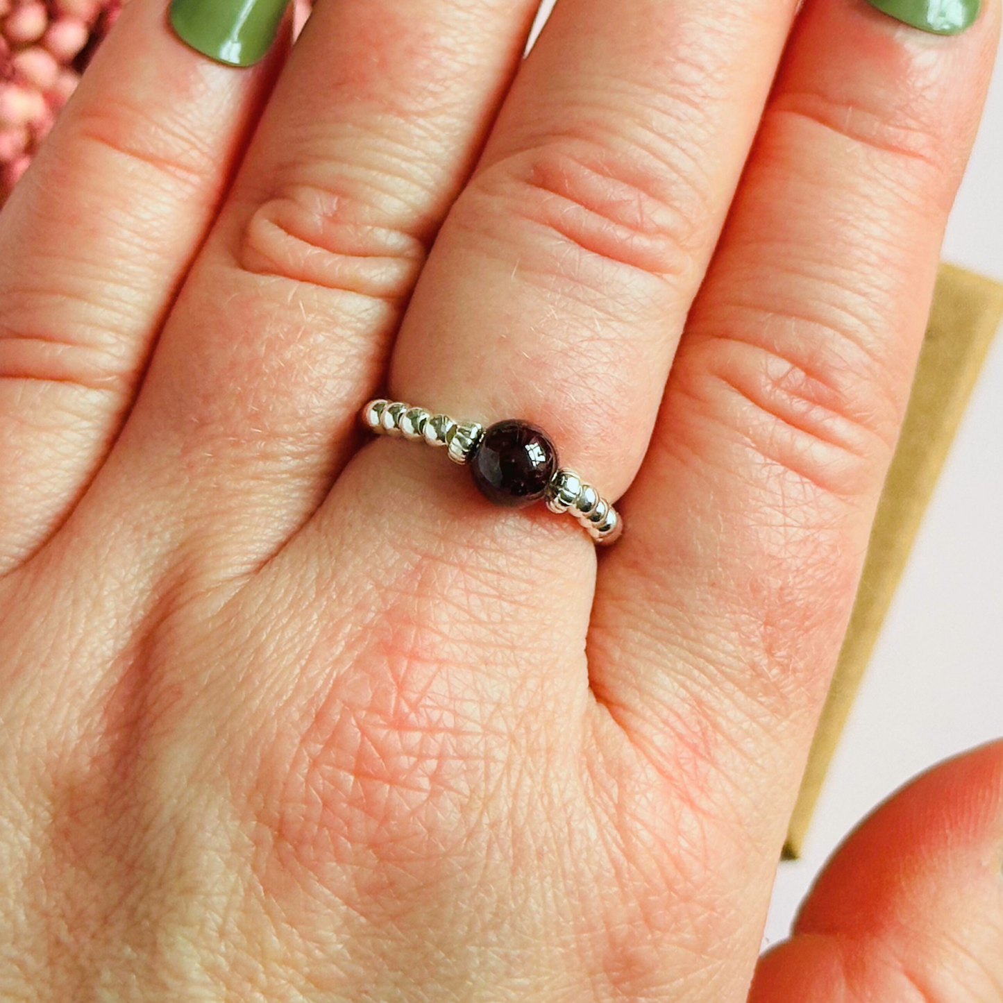 Sterling silver garnet ring featuring a 6mm smooth round garnet bead on a elasticated ring band of 2.5mm sterling silver beads.